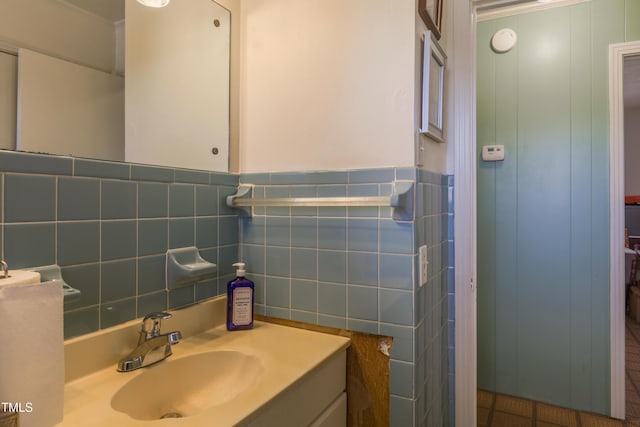 bathroom with tile walls, vanity, and tile patterned flooring