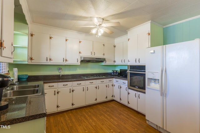 kitchen with sink, stainless steel oven, white refrigerator with ice dispenser, gas stovetop, and white cabinets