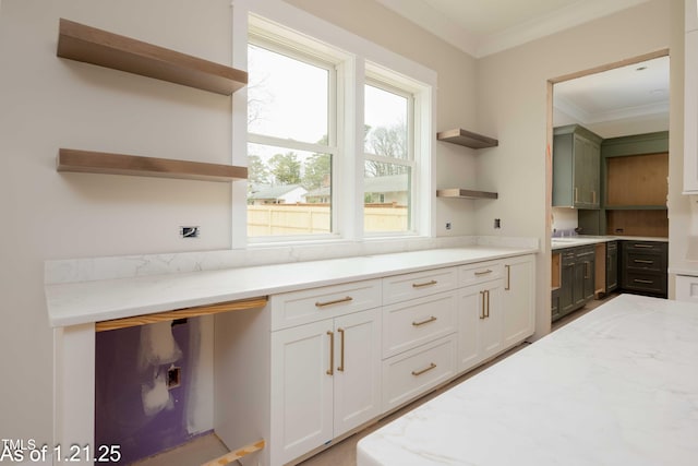 kitchen with ornamental molding, light stone countertops, white cabinets, and open shelves