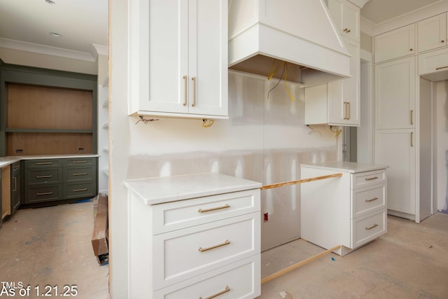 kitchen with crown molding, light countertops, white cabinets, concrete flooring, and premium range hood