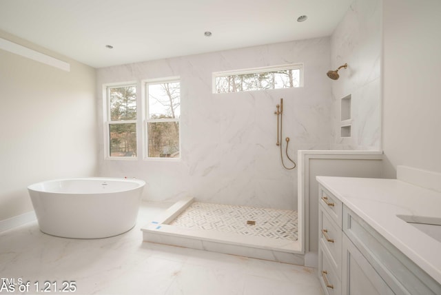 bathroom featuring marble finish floor, a freestanding bath, vanity, and a marble finish shower