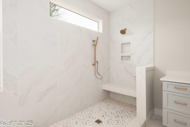 bathroom featuring a marble finish shower and vanity