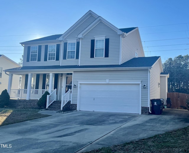 traditional home featuring covered porch, driveway, fence, and a garage