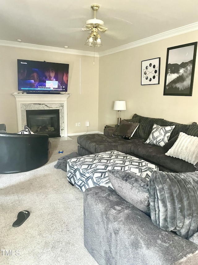 carpeted living room with ornamental molding, a premium fireplace, and ceiling fan