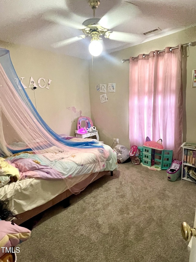 carpeted bedroom featuring ceiling fan and a textured ceiling