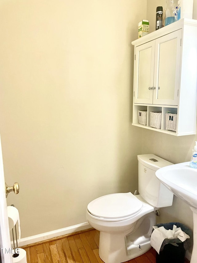 bathroom with hardwood / wood-style flooring and toilet