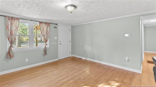 spare room with a textured ceiling and light hardwood / wood-style flooring