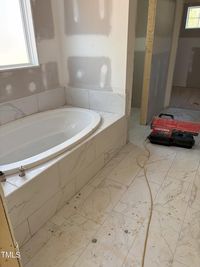 bathroom with tiled bath and plenty of natural light