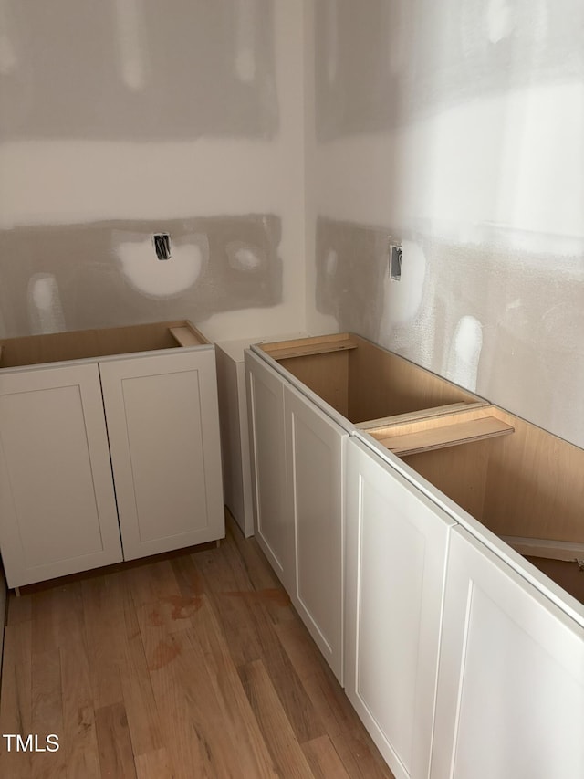 clothes washing area featuring light hardwood / wood-style floors