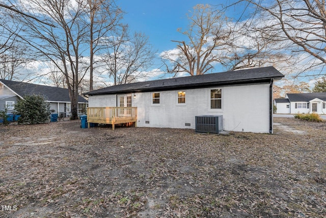 back of property with a deck and central AC