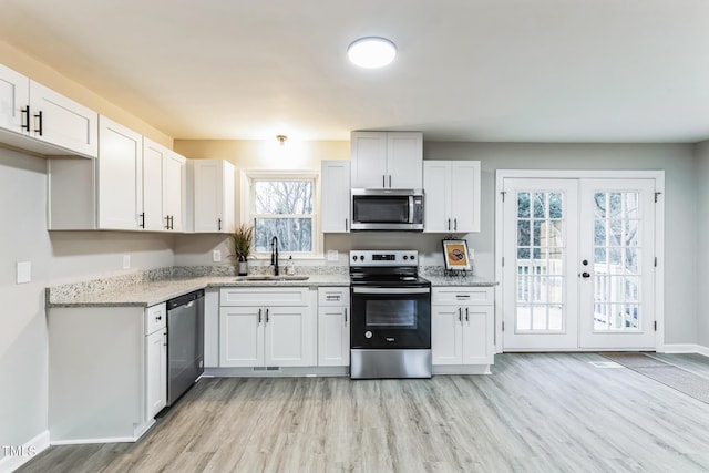 kitchen featuring sink, white cabinetry, light stone countertops, stainless steel appliances, and french doors