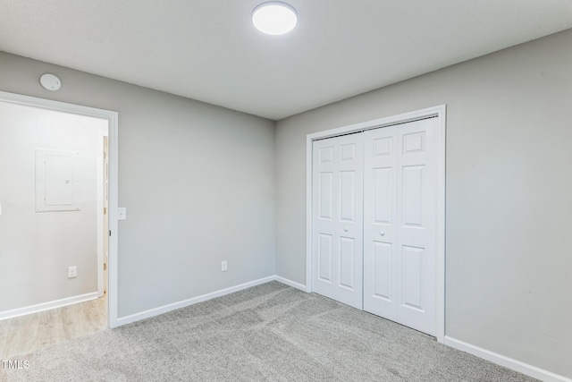 unfurnished bedroom featuring light carpet and a closet