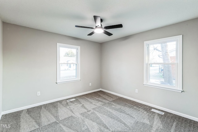 carpeted empty room featuring ceiling fan and plenty of natural light