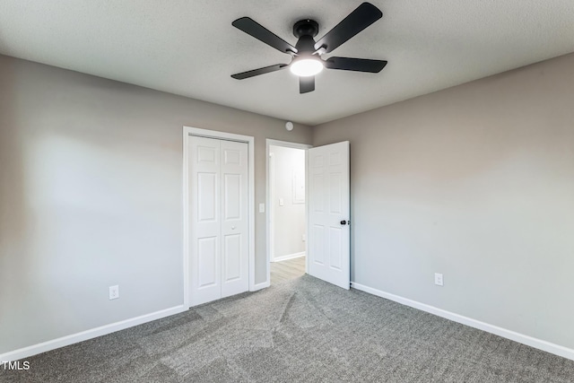 unfurnished bedroom with ceiling fan, carpet, and a closet