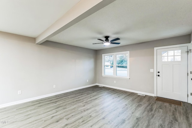 foyer featuring ceiling fan, beam ceiling, a textured ceiling, and light hardwood / wood-style flooring