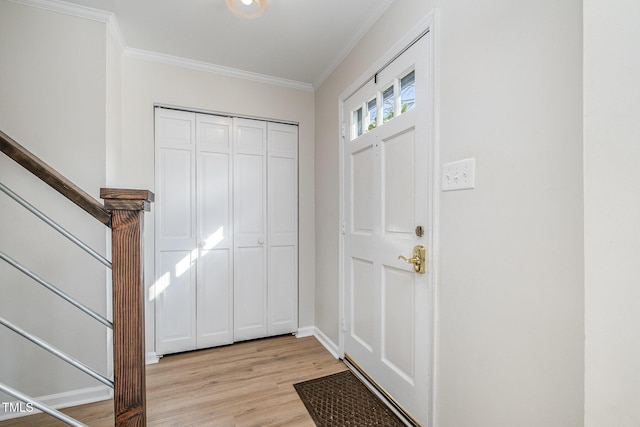 foyer with crown molding and light hardwood / wood-style floors