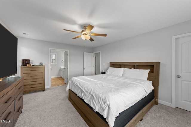 bedroom with ceiling fan, connected bathroom, and light colored carpet