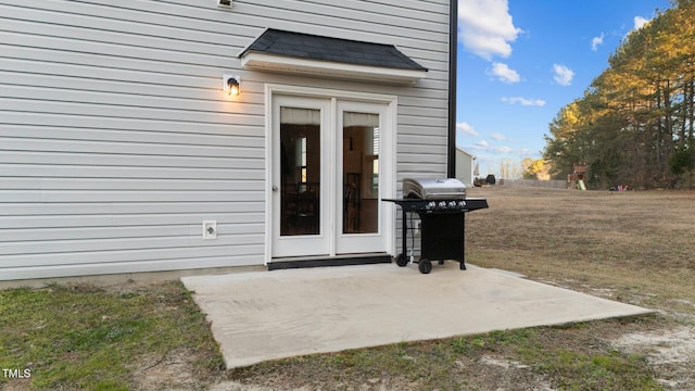 property entrance featuring a lawn and a patio