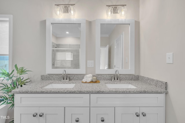 bathroom featuring an enclosed shower, vanity, and ornamental molding