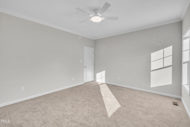 carpeted spare room with ceiling fan and crown molding