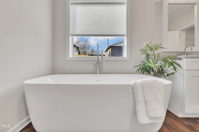 bathroom with a bath, hardwood / wood-style flooring, and vanity