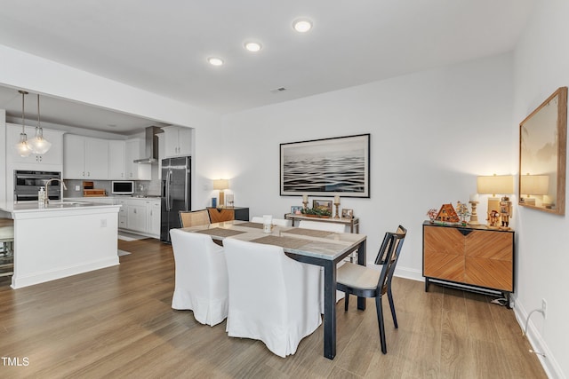 dining room with hardwood / wood-style floors and sink