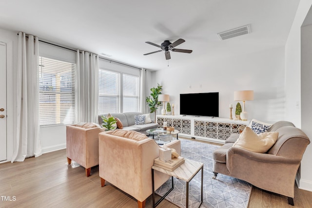 living room with ceiling fan, a wealth of natural light, and light hardwood / wood-style floors