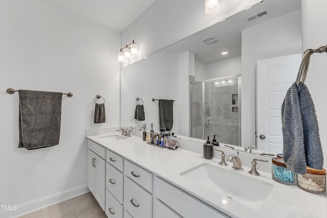 bathroom featuring a shower with door, tile patterned floors, and vanity