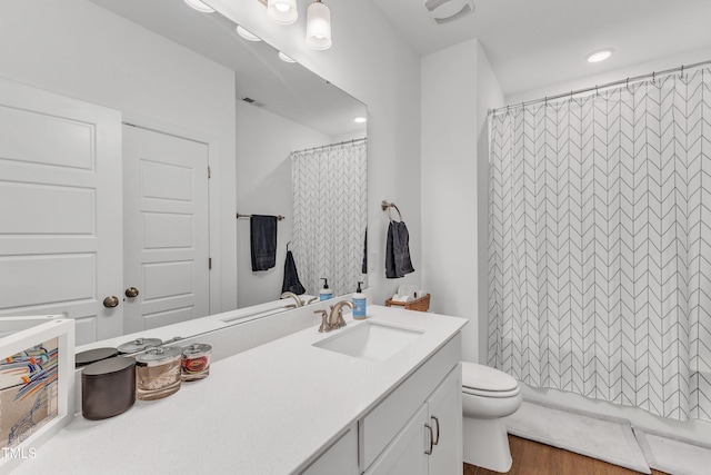 bathroom featuring toilet, vanity, walk in shower, and hardwood / wood-style floors