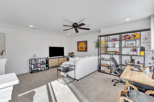 carpeted office space featuring ceiling fan