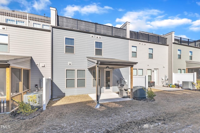 back of property with central air condition unit and a patio