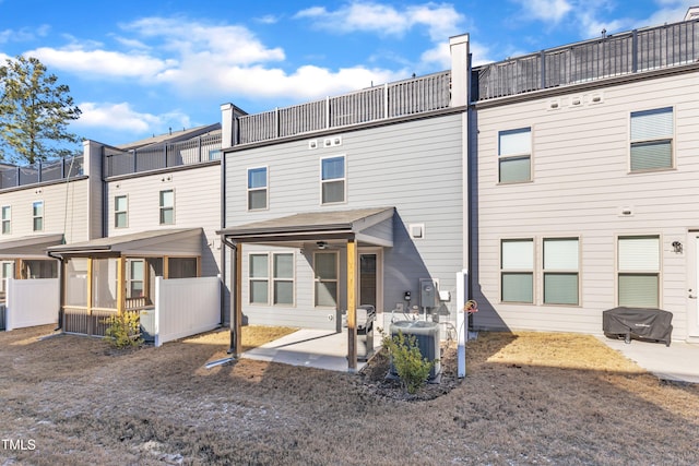 rear view of property with a sunroom, cooling unit, and a patio