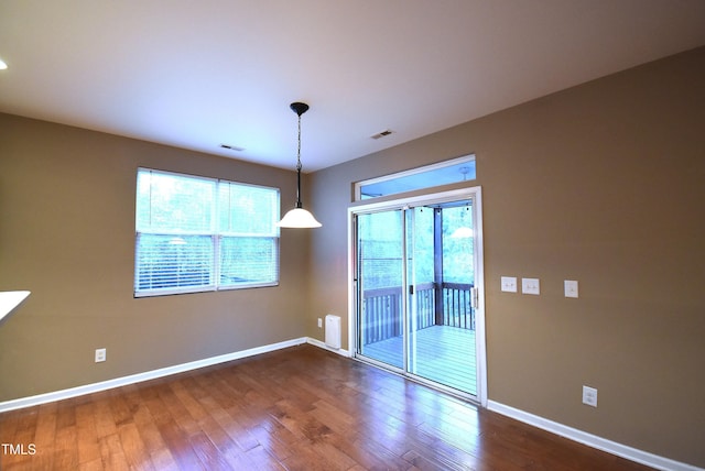 unfurnished dining area with dark wood-type flooring