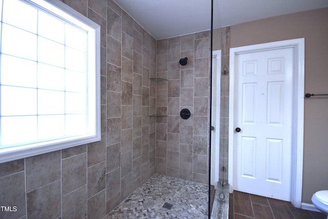 bathroom featuring toilet and a tile shower