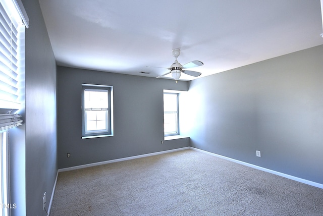 unfurnished room with ceiling fan, a wealth of natural light, and carpet flooring