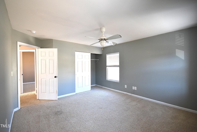 unfurnished bedroom featuring ceiling fan, a closet, and carpet flooring