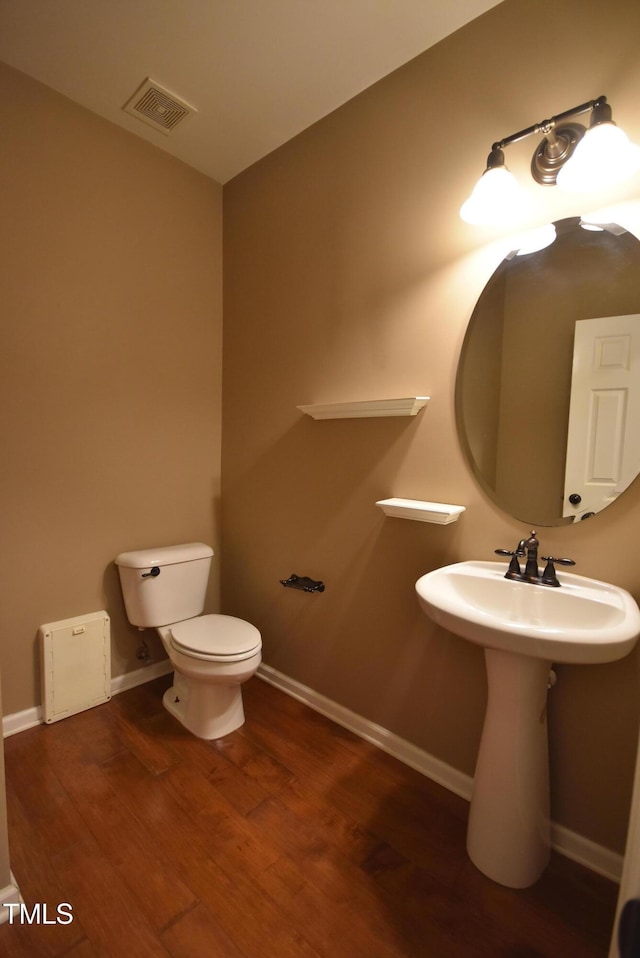 bathroom with toilet and hardwood / wood-style floors