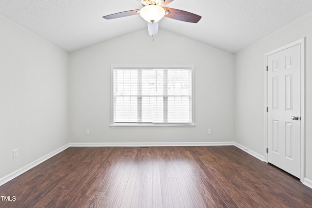 unfurnished bedroom with ceiling fan, dark wood-type flooring, a textured ceiling, and lofted ceiling