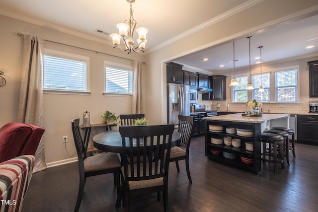 dining room with crown molding, dark hardwood / wood-style floors, and a chandelier