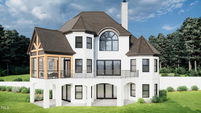 rear view of house with a lawn, a balcony, a chimney, a patio area, and stucco siding