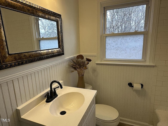 bathroom featuring vanity, a wealth of natural light, and toilet