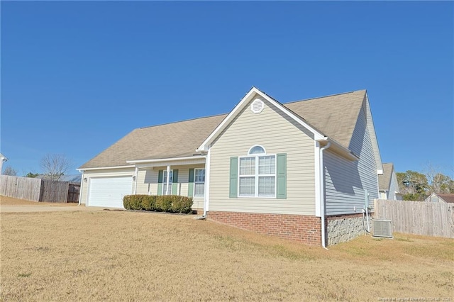 view of front of home featuring a garage, cooling unit, and a front lawn