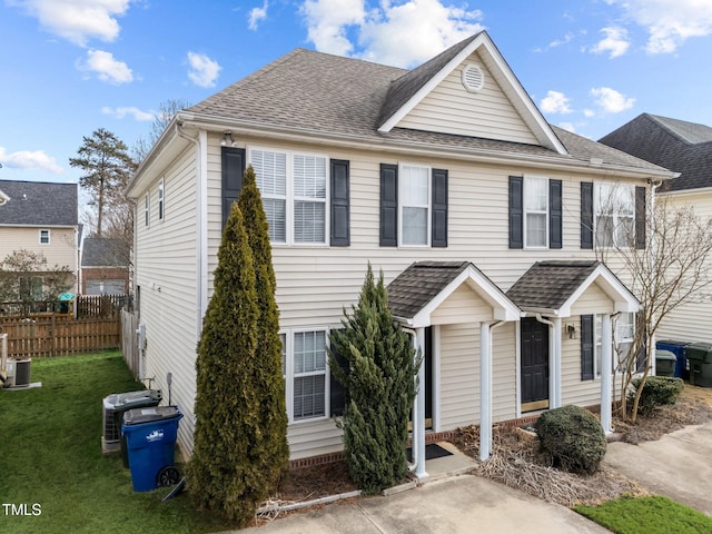 view of front of property featuring a front lawn and central AC