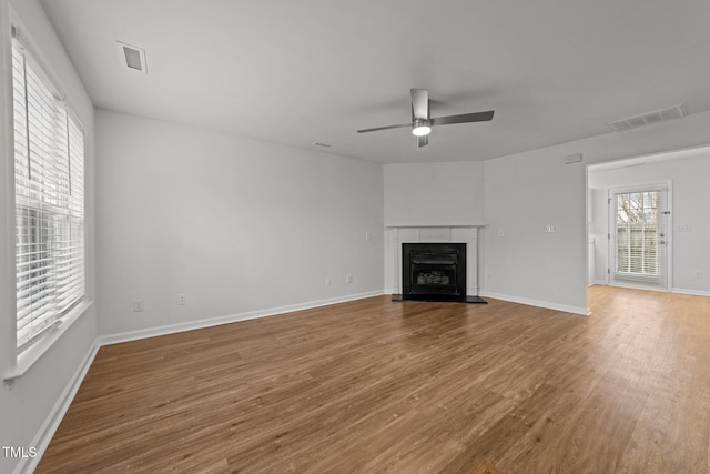 unfurnished living room featuring hardwood / wood-style flooring, a healthy amount of sunlight, and ceiling fan