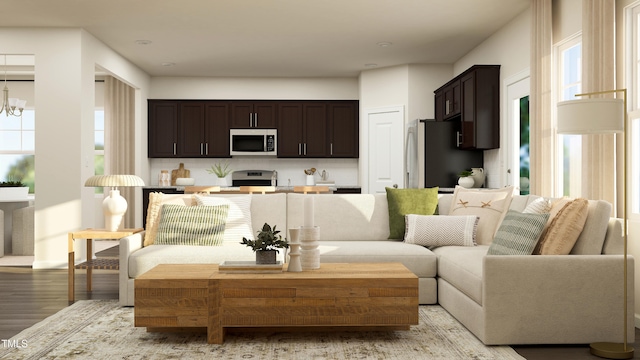 living room with light wood-type flooring and an inviting chandelier