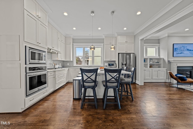 kitchen featuring white cabinetry, stainless steel appliances, and hanging light fixtures