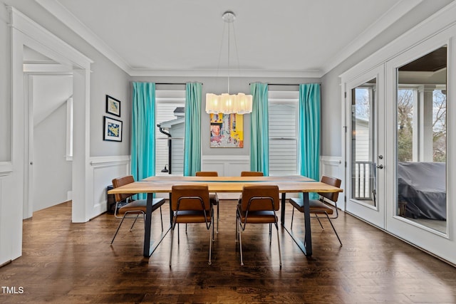 dining space featuring crown molding, dark hardwood / wood-style floors, a notable chandelier, and french doors