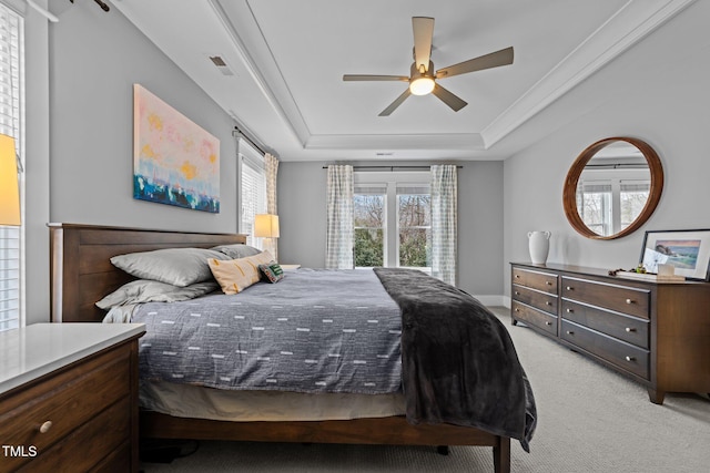 carpeted bedroom featuring a raised ceiling and ceiling fan