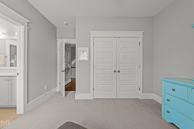 carpeted bedroom with a closet and ensuite bathroom