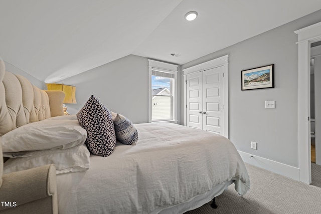 bedroom featuring lofted ceiling, carpet floors, and a closet